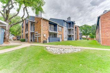 A brick building with a green lawn in front.